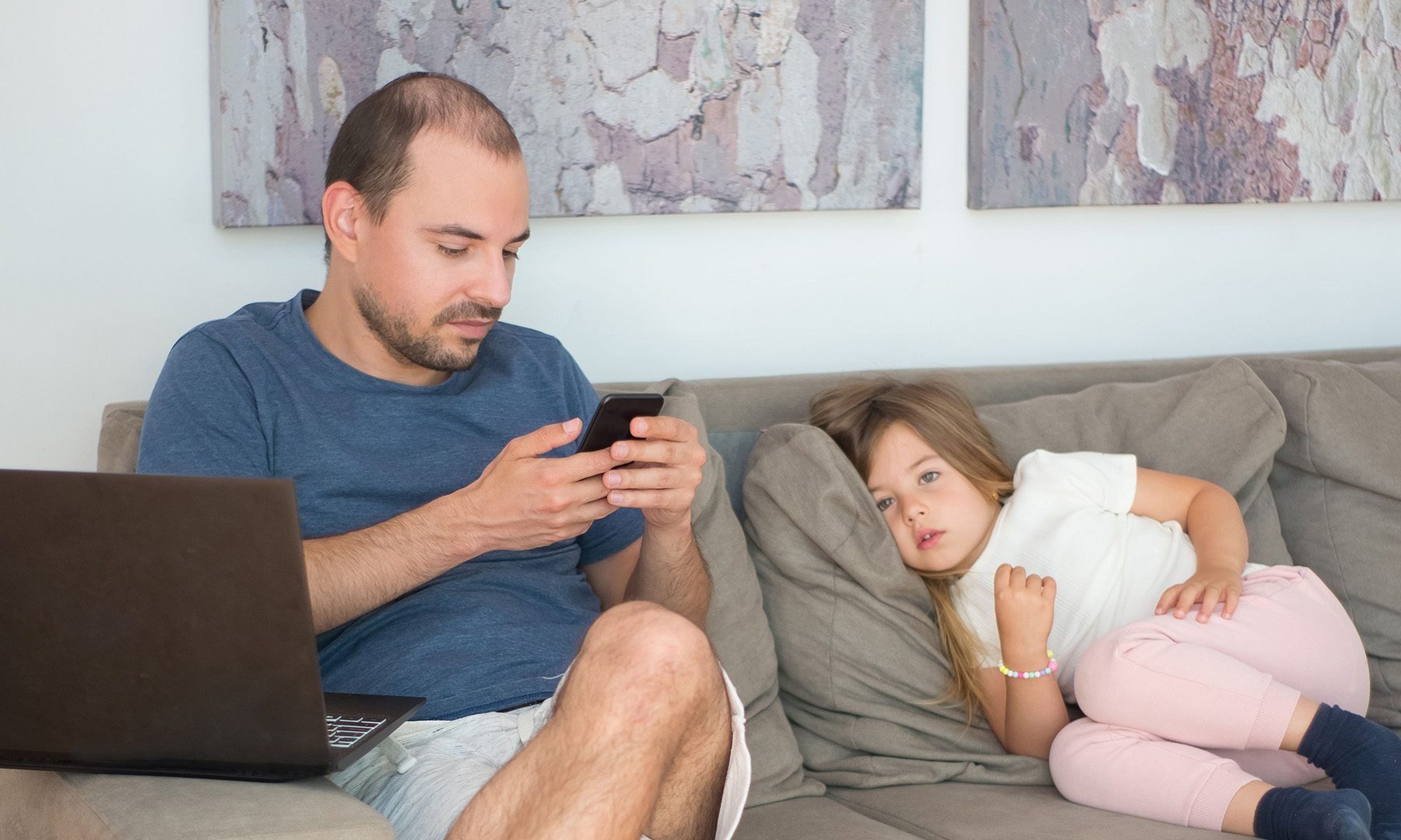 Father and daughter focus on digital devices