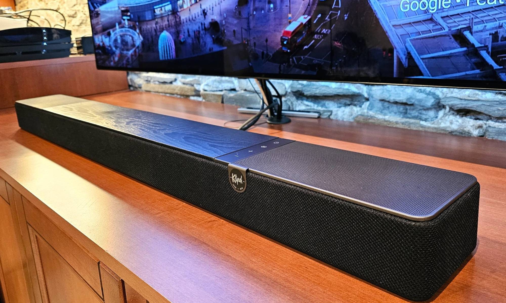 Klipsch Flexus Core 200 placed in front of TV on a wooden cabinet
