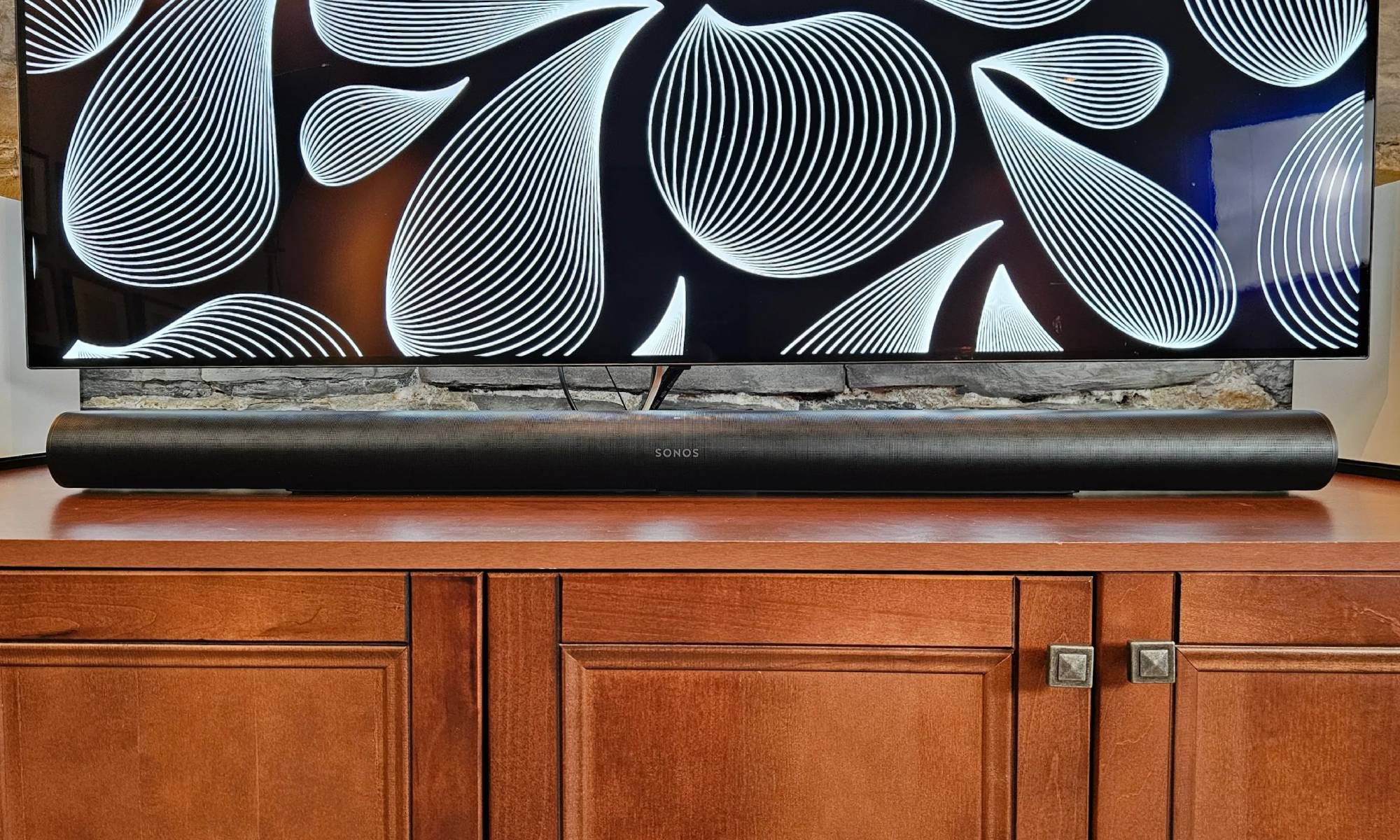 Sonos Arc Ultra placed underneath a TV on a wooden cabinet