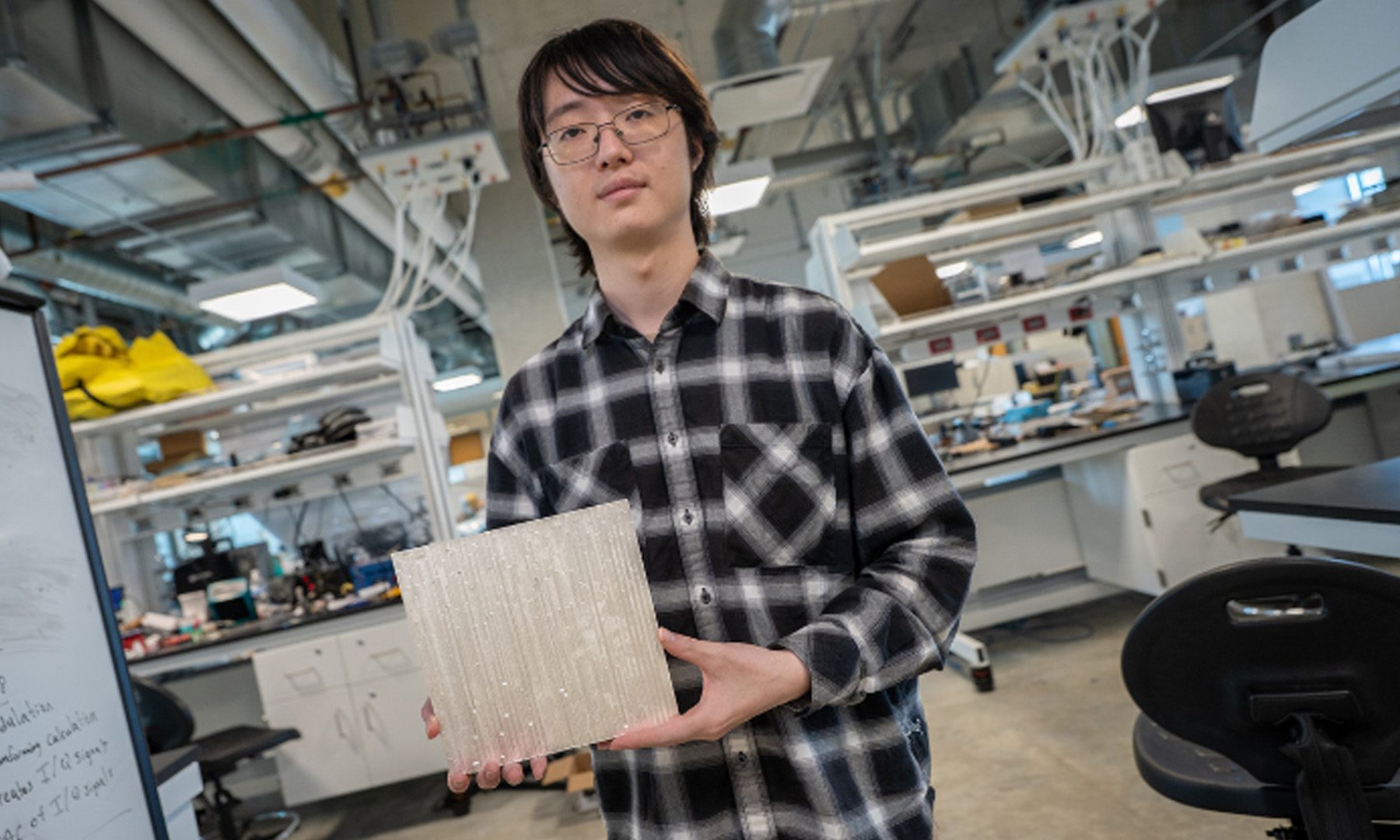 Wuqiong Zhao, UC San Diego PhD student and study co-author, holds a reflective tile.