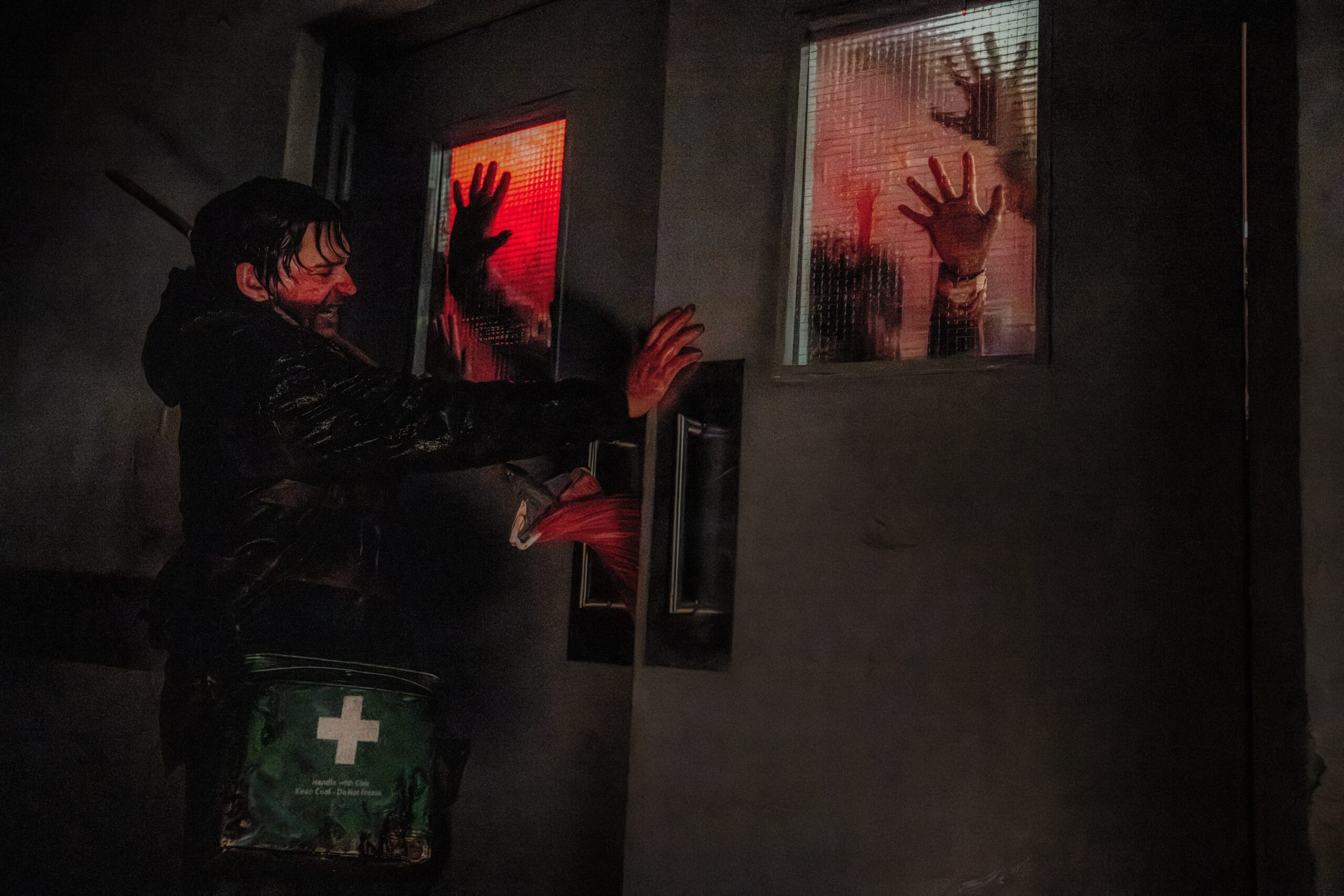 Austin Abrams afasta uma horda de zumbis no filme Resident Evil de 2026.