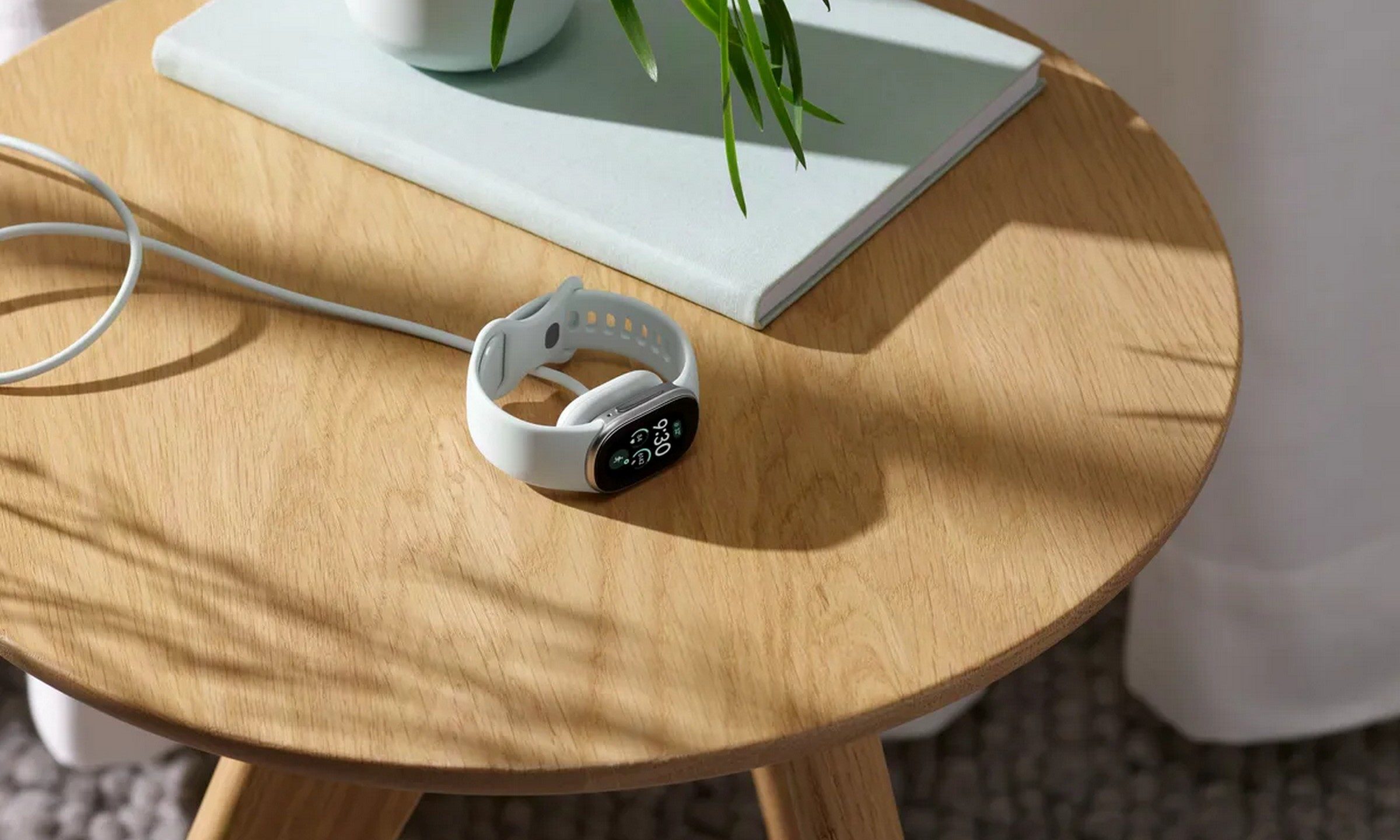 Google Fitbit Edge charging on a table