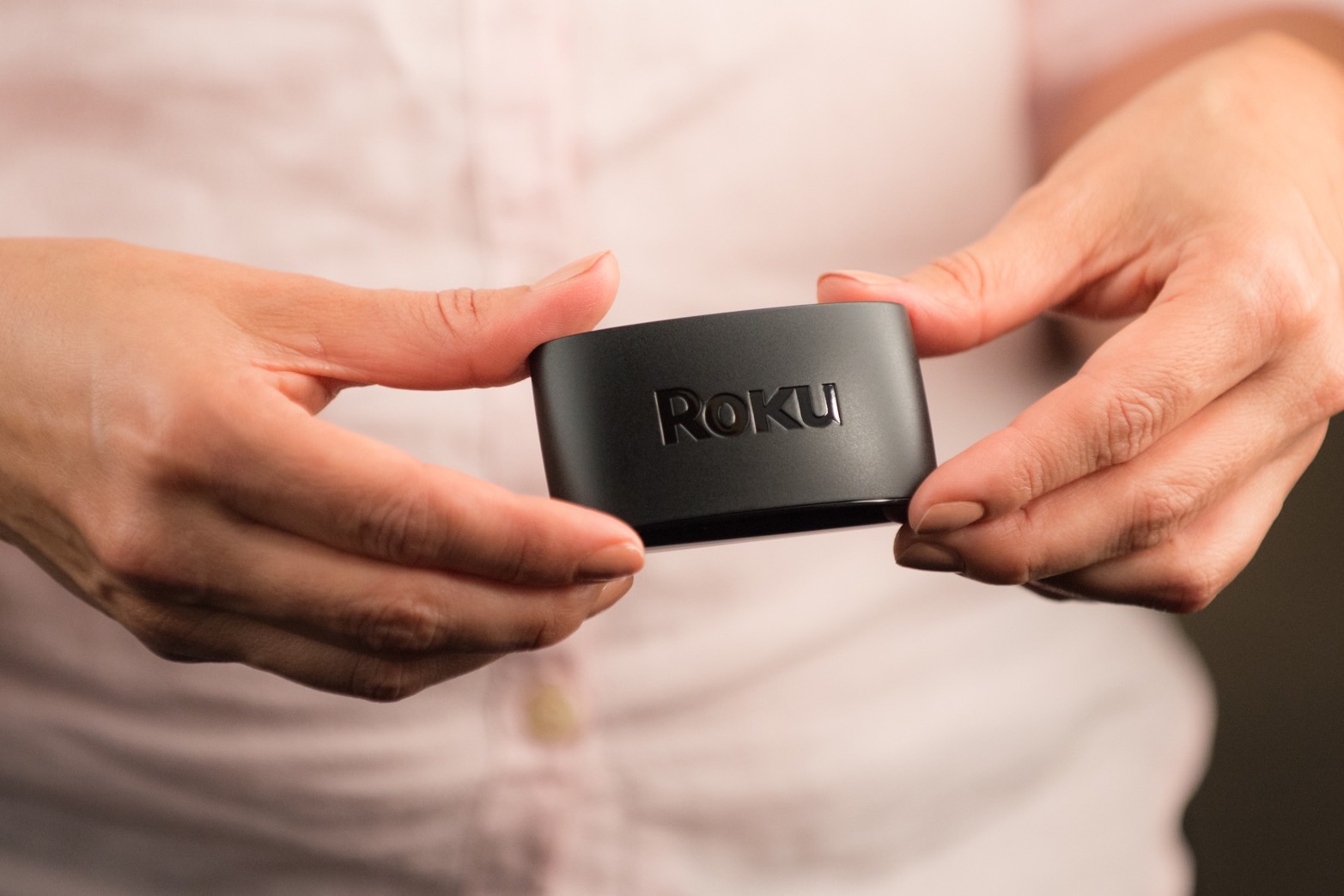 Roku Express in a person's hands.