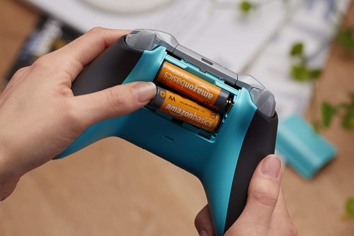 AmazonsBasics AA batteries being inserted into a game controller.