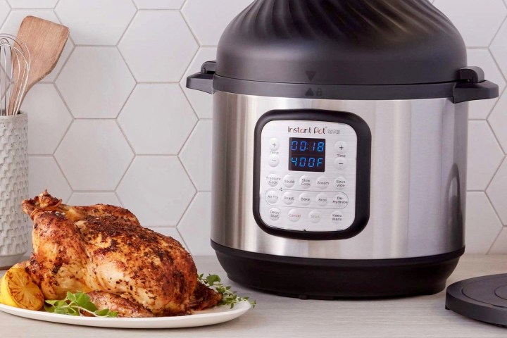 Instant Pot Duo Crisp with Air Fryer Lid sits next to a cooked chicken.