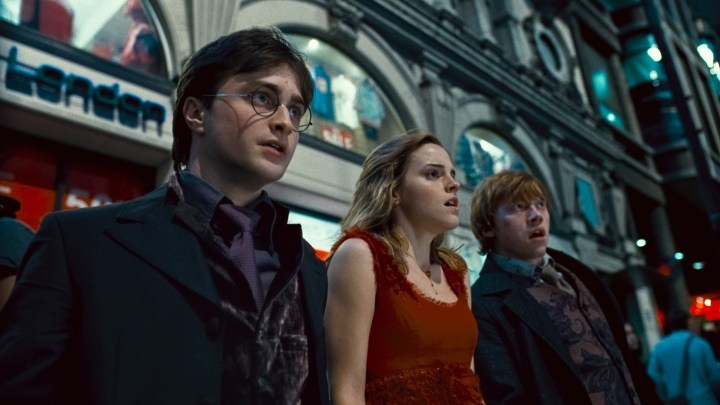Harry, Ron, and Hermione looking scared in the middle of a crowded street in HP and the Deathly Hallows Part 1
