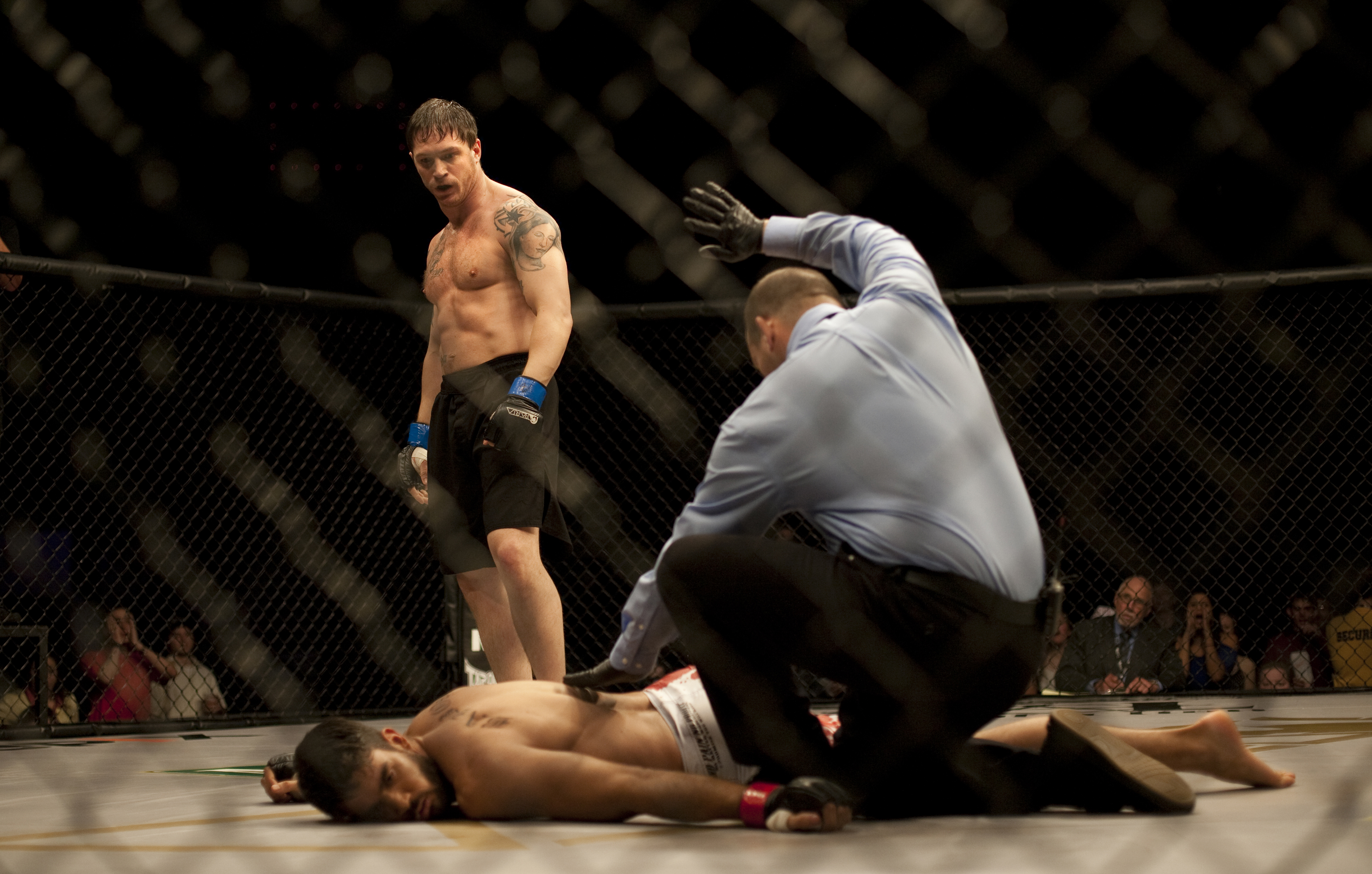 A man stands above his opponent in the octagon.