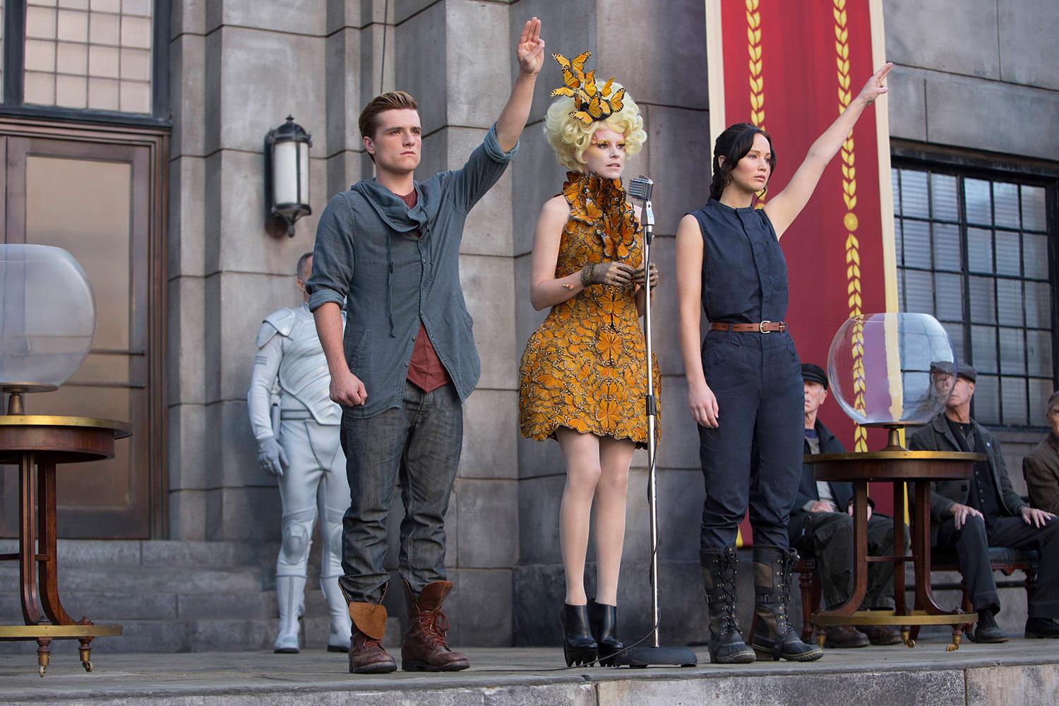 Characters salute in a scene from The Hunger Games Catching Fire.