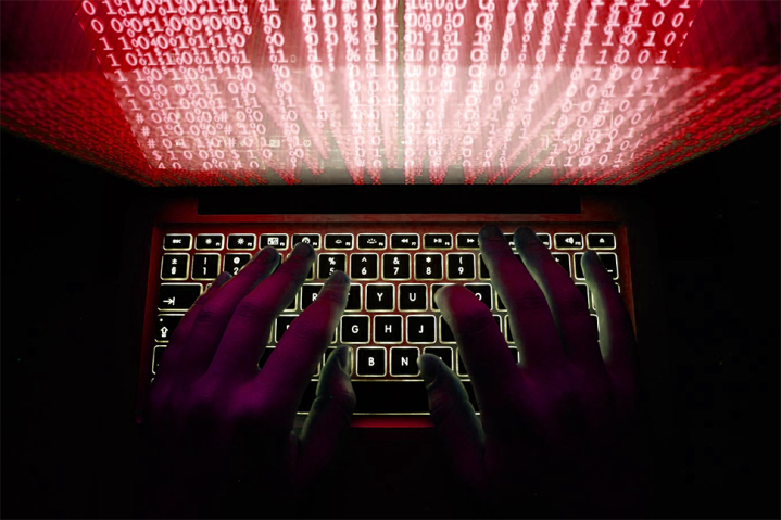 A representation of a hacker using a laptop.