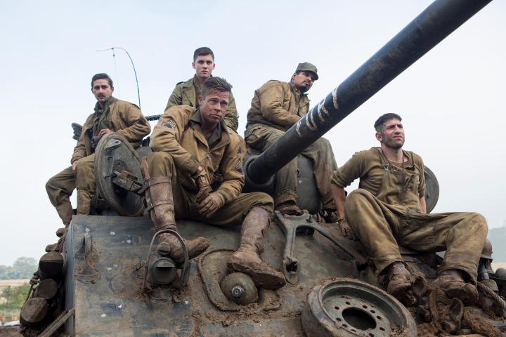 Five men sit on a war tank.