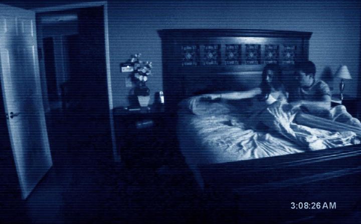 A couple in bed while a camera records them in the film "Paranormal Activity."
