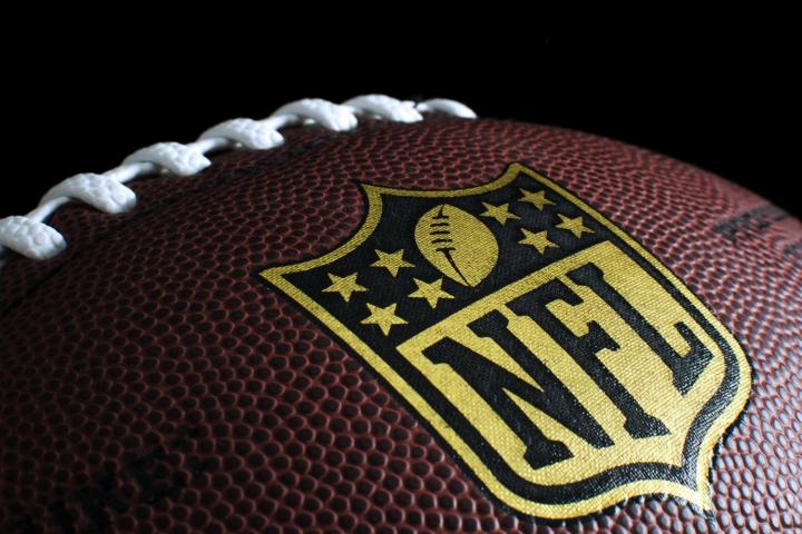 A football with the NFL logo on it in gold.