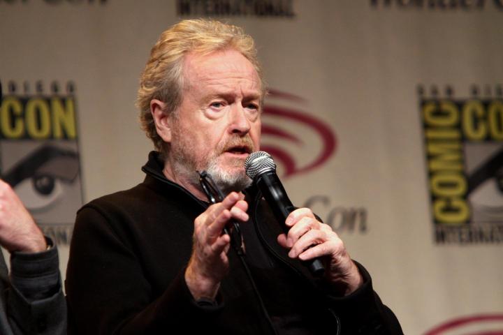 Ridley Scott holds a microphone and talks.