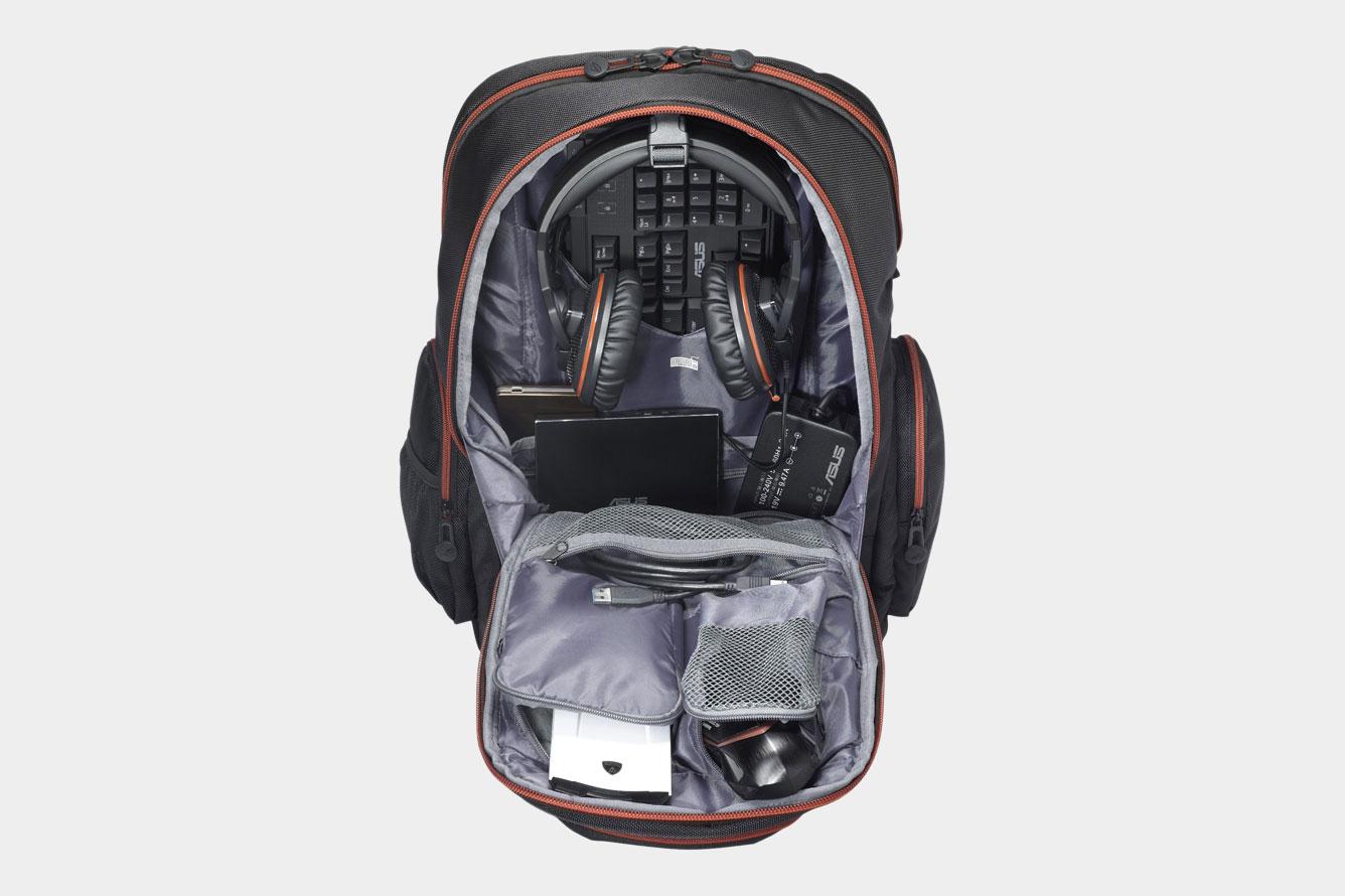 A front view of a an Asus ROG Nomad V2 backpack with it's front side opened and filled with various tech accessories.