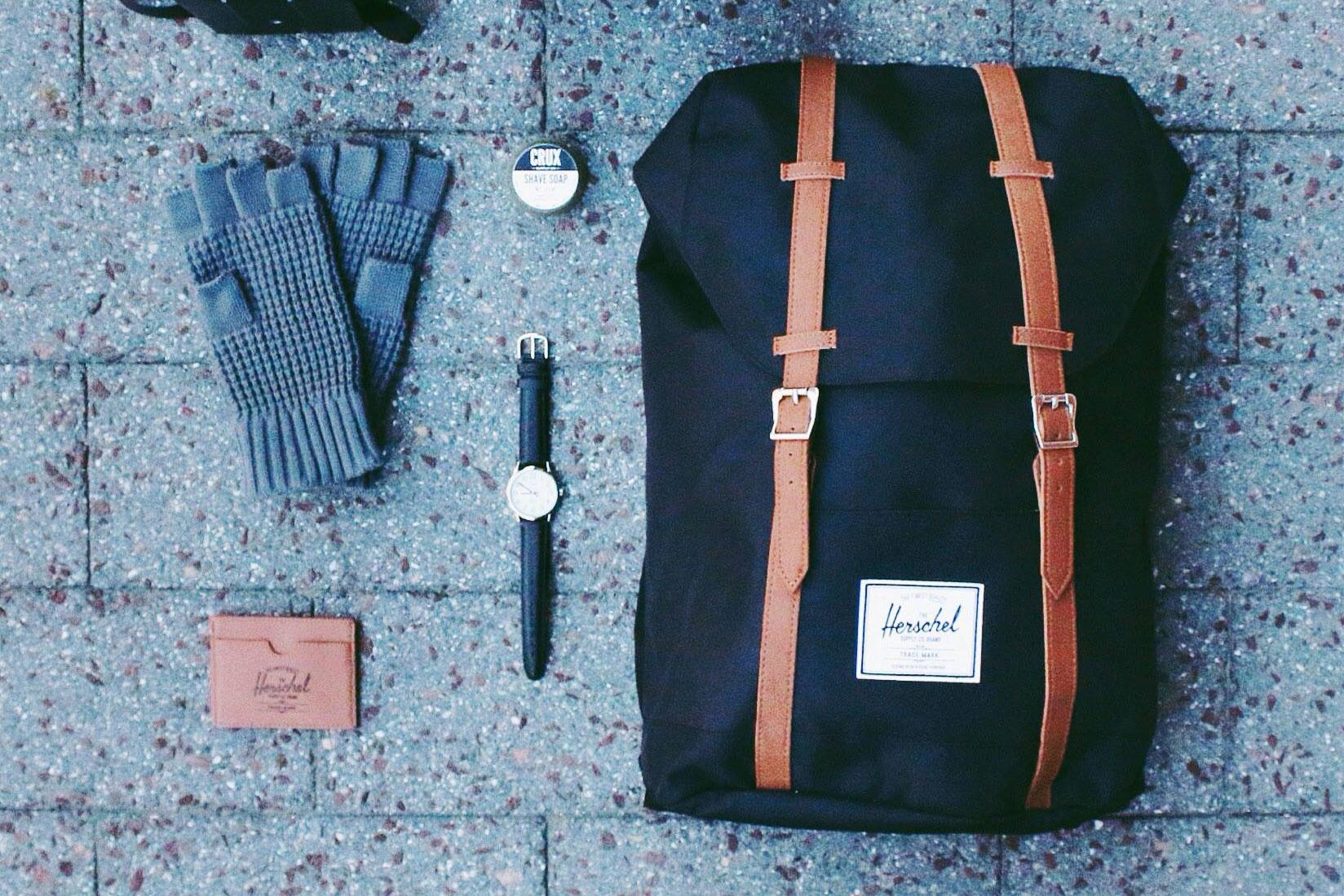 Herschel Supply Co. Retreat backpack displayed with a watch, floves, wallet, and other accessories.