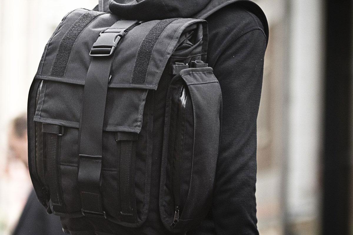 A close up profile rear view of a person wearing a Mission Workshop R6 Arkiv Field Pack.