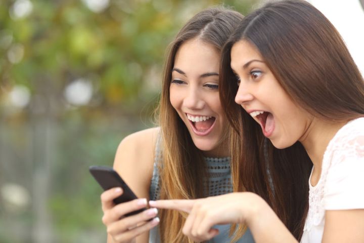 girls laughing at phone.