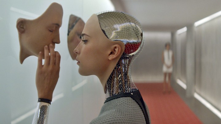 An android touches a face on the wall in Ex Machina.