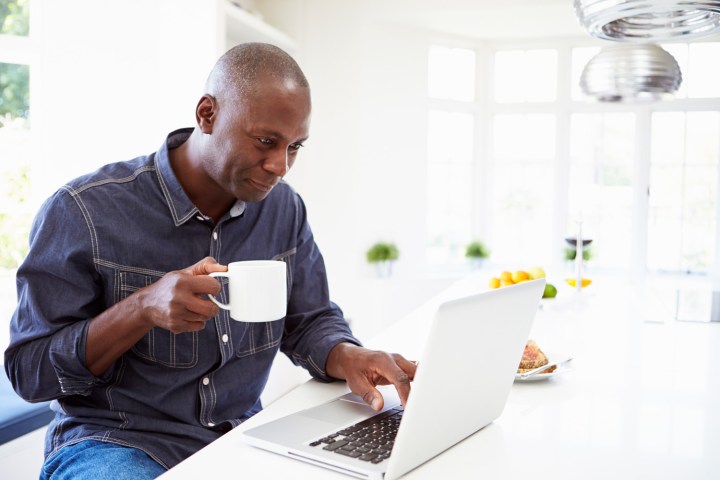how to download torrents man downloading on computer with coffee