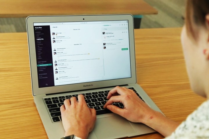 A person using Slack on a Macbook.