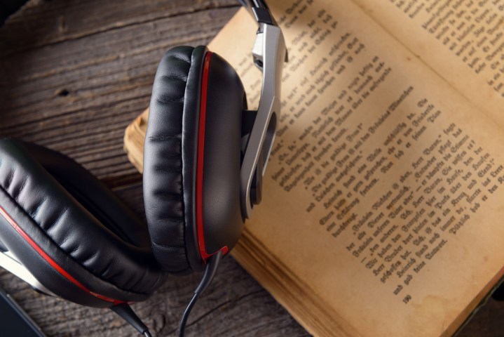 estories audiobook 32511116  headphones on the old book concept of listening to audiobooks