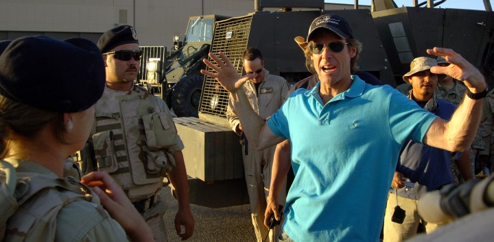 Michael Bay holds his hand up on Transformers set.