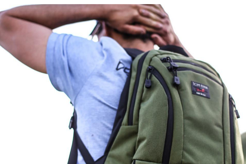 A close up view of a Tom Bihn Synapse 19 backpack being worn by a person.