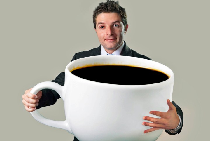 coffee not carcinogenic superheated beverages are young happy business man holding a funny huge and oversized cup of black 15