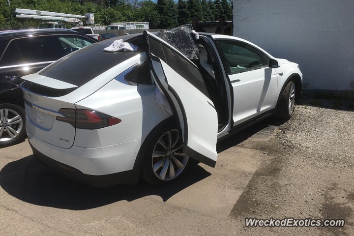 tesla model x falcon wing door ripped off with by garage 900x600
