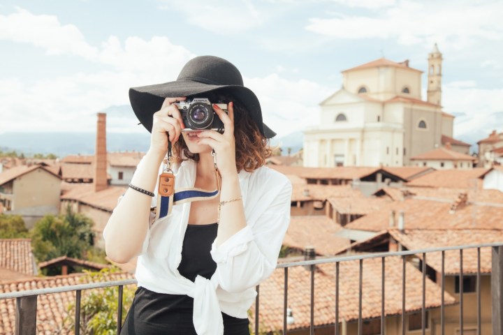 expedia acquisition acquires trover travel photography young woman wearing straw hat photographing old town