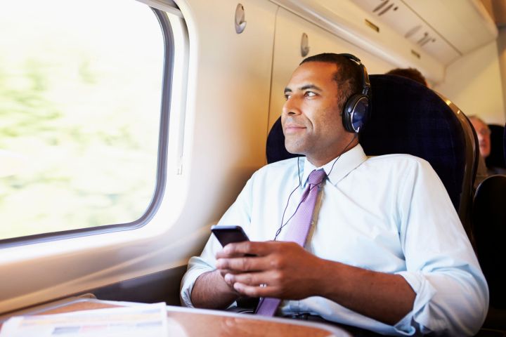 iheartmedia launches two new streaming services 28159403  businessman relaxing on train listening to music