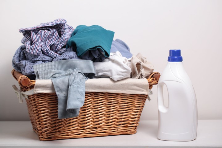 how much laundry detergent should you use 38735149  dirty clothes in the basket and a bottle of