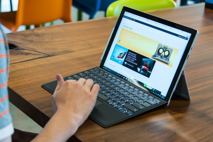Someone using a Surface Pro 4 on a table.