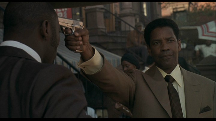 Denzel Washington sostiene una pistola en American Gangster.