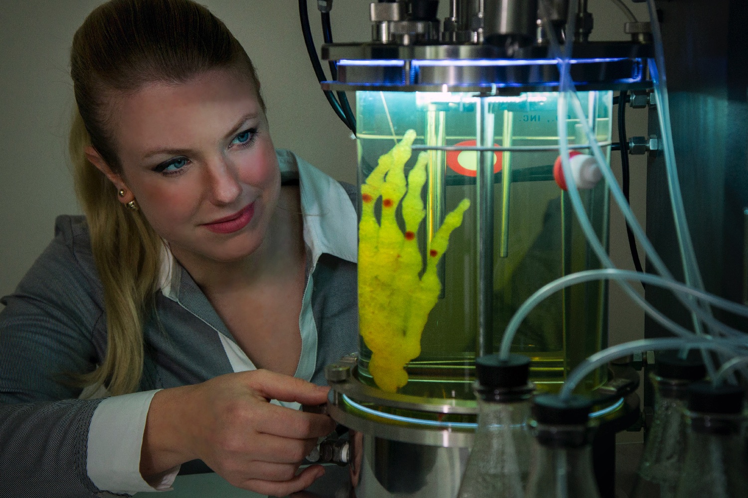 3d printed hand lab amy karle next to her artwork regenerative reliquary in bioreactor  photo by blue bergen