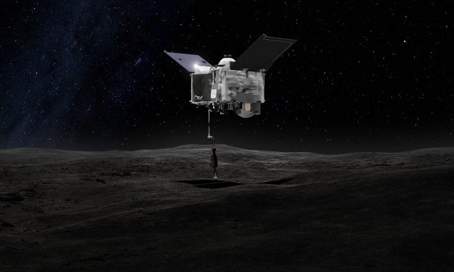 This artist's rendering shows the OSIRIS-REx spacecraft collecting a sample from the asteroid Bennu using a mechanical arm to touch the asteroid's surface.