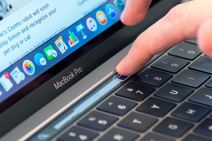 A user adjusting a slider on the MacBook Pro TouchBar.