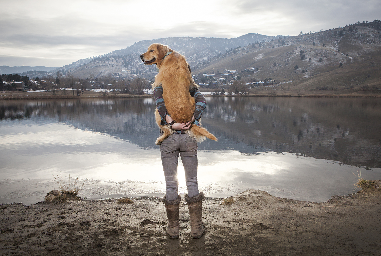 2017 photography trends woman holding her golden retriever at lake