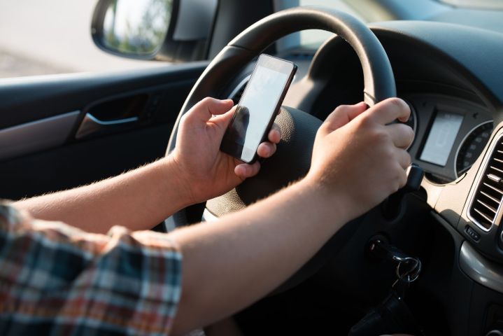 ai texting and driving talking while  hands of young man on steering wheel