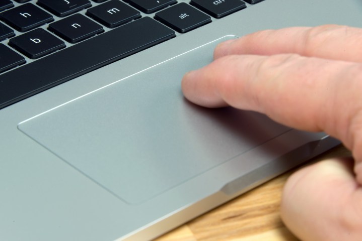 شخصی با دو انگشت صفحه لمسی ASUS Chromebook Flip C302CA را لمس می‌کند.