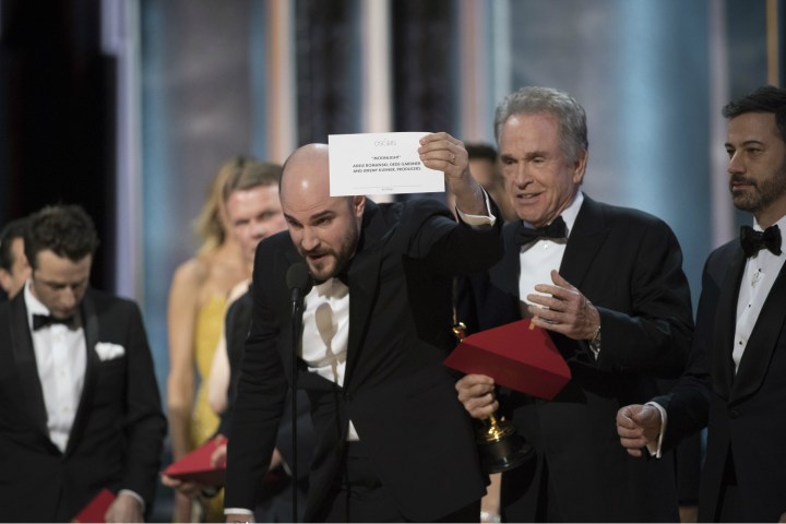 A man holds up an envelope at the 2017 Oscars.