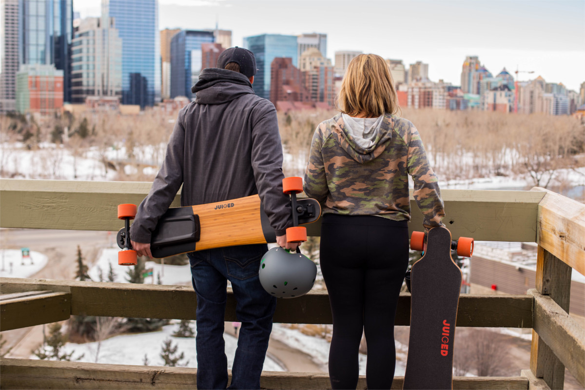 juiced electric skateboard couple holding juicedboards