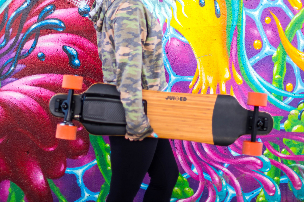 juiced electric skateboard girl holding juicedboard