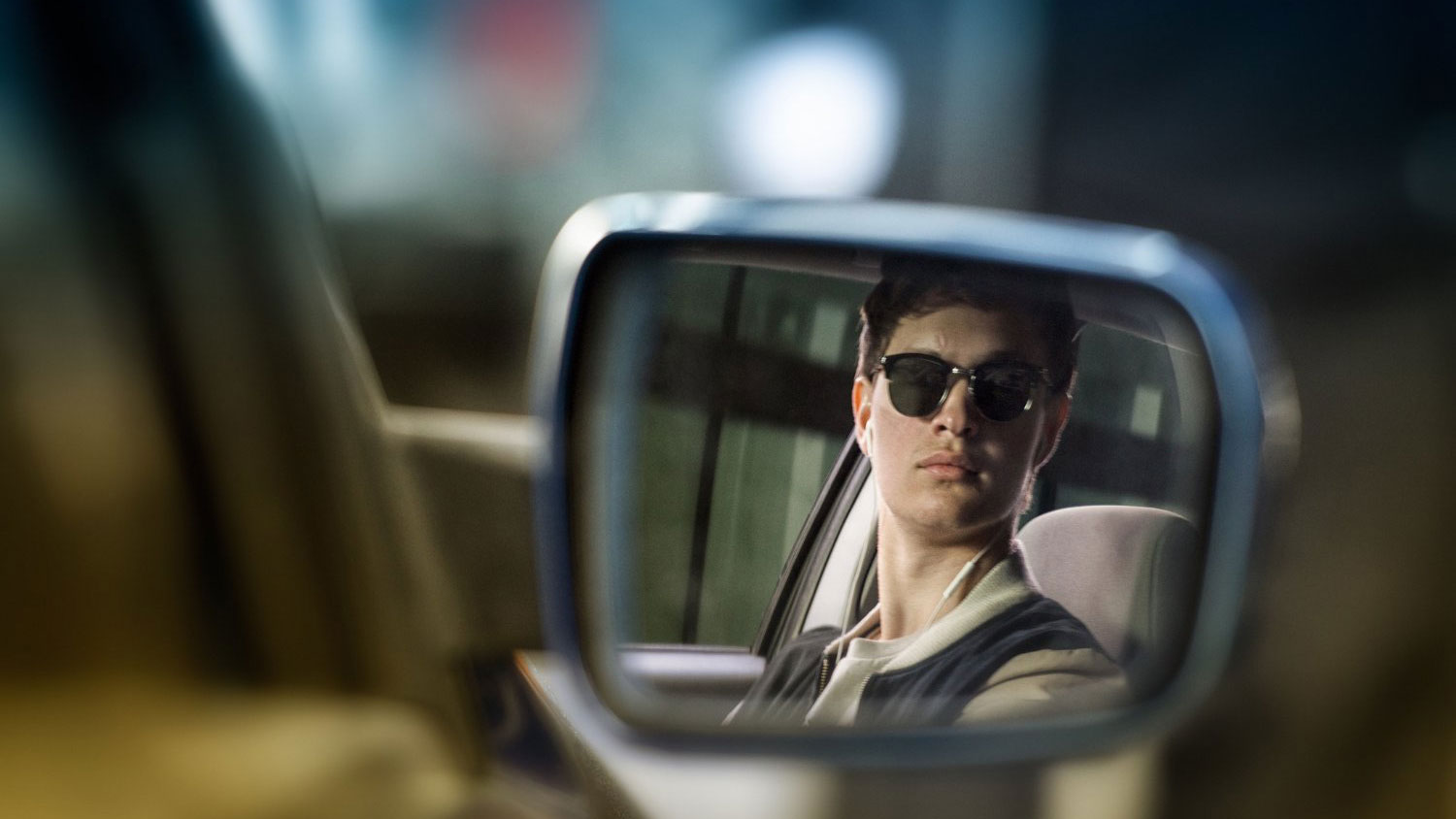 Um homem olha pelo espelho retrovisor em Baby Driver.