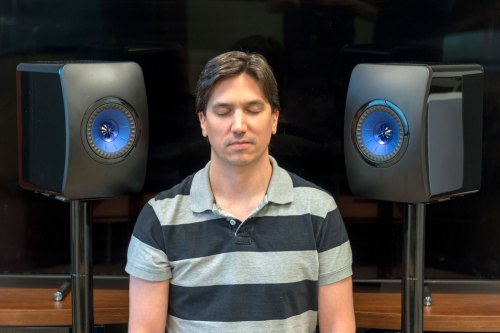 Man listening to KEF LS50 speakers with eyes closed.