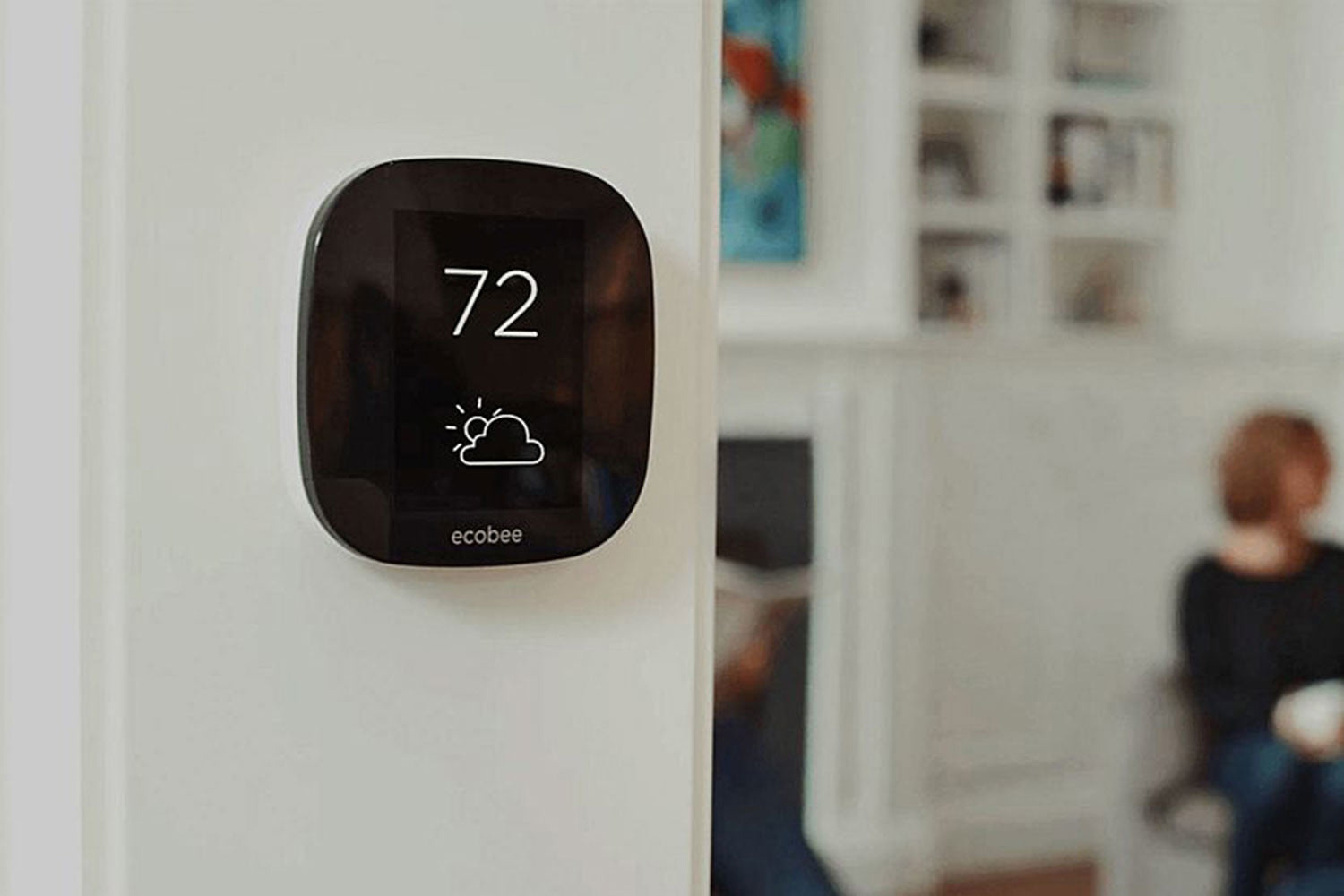 Ecobee4 smart thermostat mounted near living room.