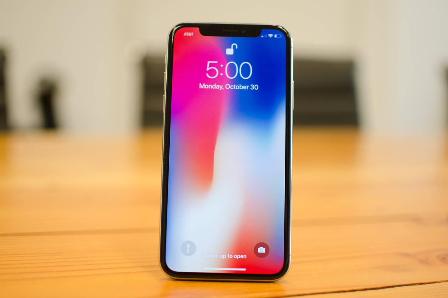 Apple iPhone X screen upright on a table.