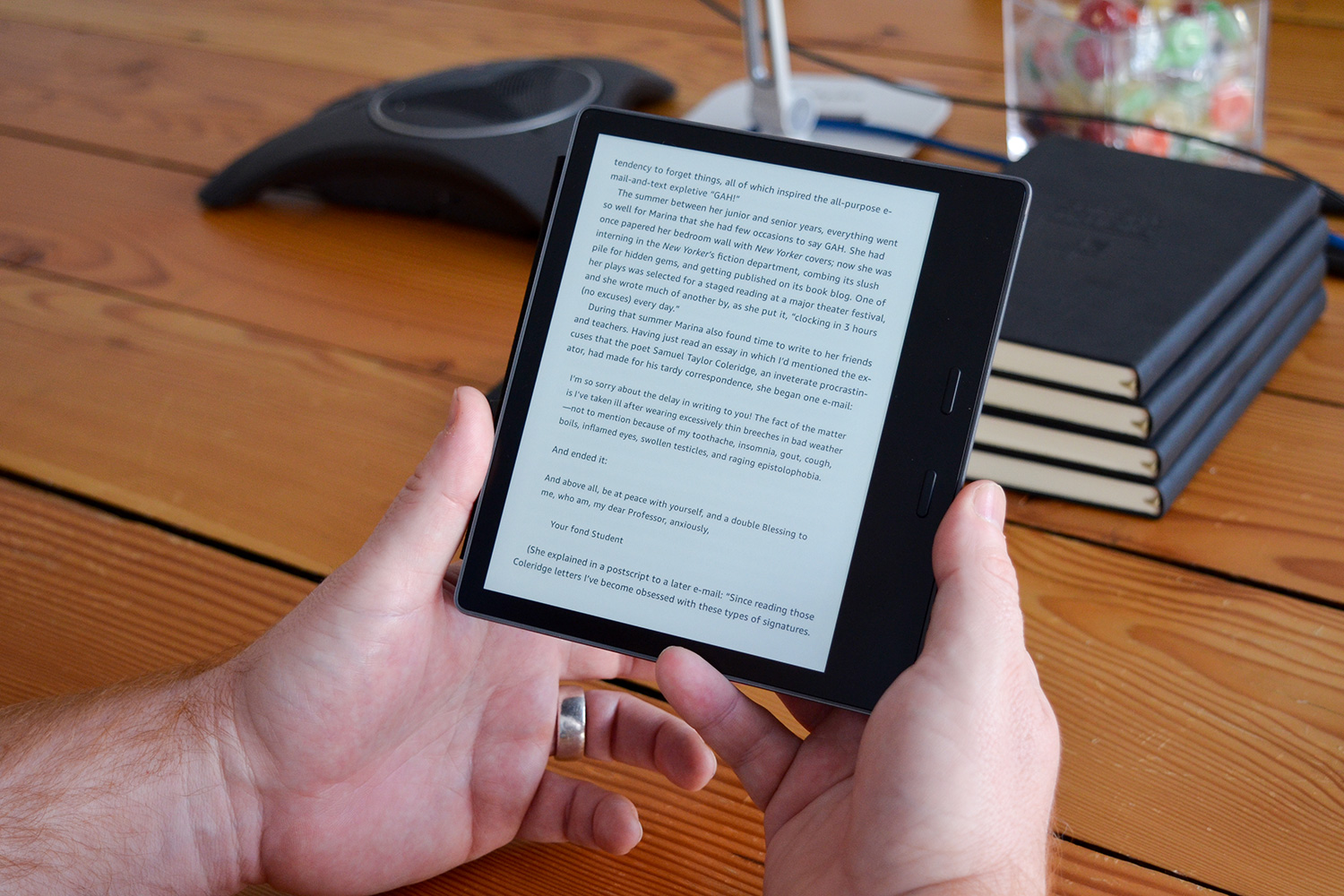 Um homem lê um texto em um Amazon Kindle Oasis. 
