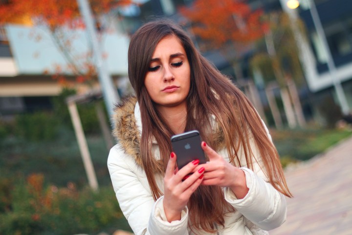 Woman Using iPhone planned obsolescence global sales