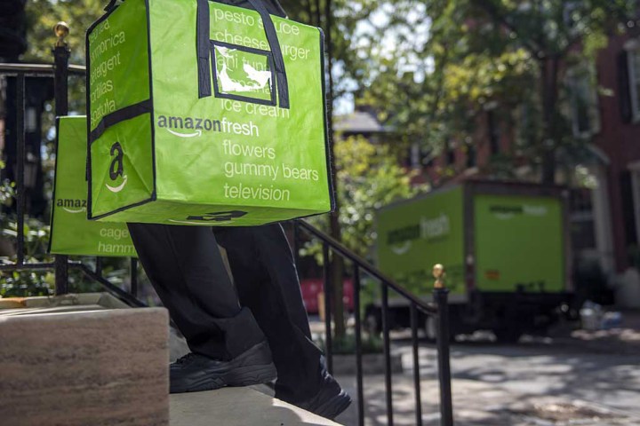 A person delivery an Amazon Fresh order to a customer's home.
